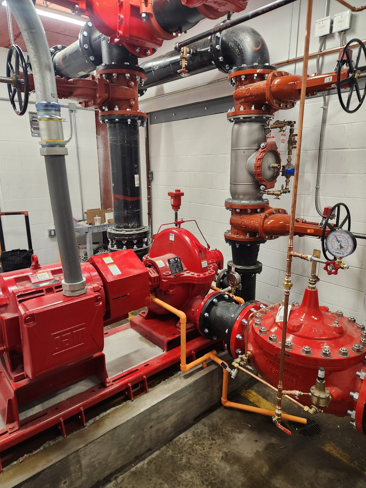 Commercial fire pump room with motor, pump, and risers